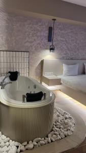 a large bathroom with a tub and a bed at Avwan Hotel Çiğli in Izmir