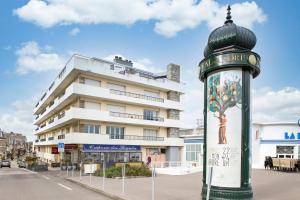 un edificio con una señal de calle delante de un edificio en Val Détente - Appartement à proximité immédiate de la plage, en Pléneuf-Val-André