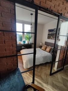 Pokój z łóżkiem i ceglaną ścianą w obiekcie Warszawa - Apartament Chomikówka w Warszawie