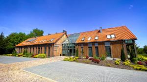 a large wooden building with windows and a building at Gościniec Folwark Nadawki in Białystok