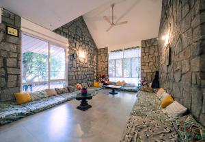 a living room with a couch and a stone wall at BYOC Hostels in Bangalore