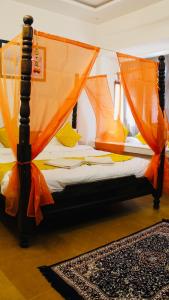 een bed met een oranje luifel in een kamer bij Hotel Dara & Camel Safari in Jaisalmer