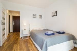 Un dormitorio blanco con una cama con toallas azules. en great location Zablocie wifi balcony, en Cracovia