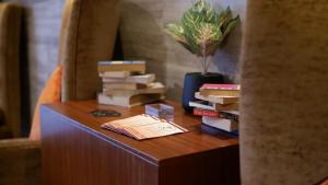 a table with books on it next to a vase with a plant at On 8 Sukhumvit Nana Bangkok by Compass Hospitality in Bangkok