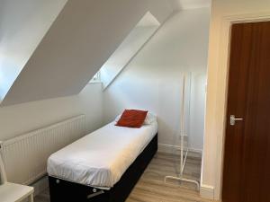 a small room with a small bed in a attic at Lovely 2-bedroom apartment in the heart of chelmsford in Chelmsford