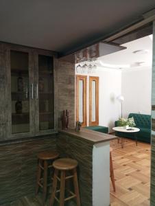 a kitchen with a counter and stools in a room at Jacquard Apartment in the centre of Kutaisi in Kutaisi