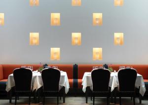 a dining room with white tables and black chairs at Ham Yard Hotel, Firmdale Hotels in London +24 photos