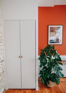 um armário branco num quarto com uma planta em Les Balcons de Kéréon em Quimper