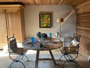 a dining room with a table and two chairs at La Maison d'Arc Chambres et Tables d'Hôtes in Frasnes-lez-Anvaing