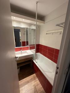 W łazience znajduje się wanna, umywalka i lustro. w obiekcie Ski-in ski-out 1 bed, La Tania w Courchevel