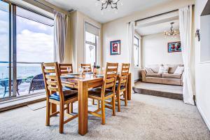 a dining room with a table and chairs and a couch at Pass the Keys Stunning Sea Front Views in Westcliff-On-Sea