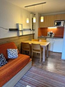 a kitchen and dining room with a couch and a table at Ski-in ski-out 1 bed, La Tania in Courchevel