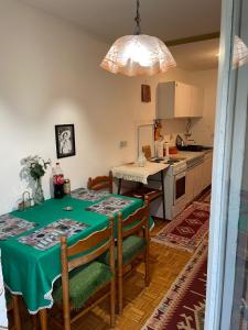 a kitchen with a table with a green table cloth at Bronze Apartment in Sarajevo