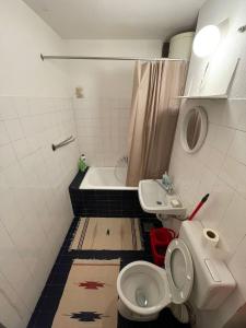 a bathroom with a toilet and a sink and a tub at Bronze Apartment in Sarajevo
