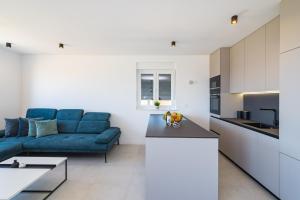 salon z niebieską kanapą i kuchnią w obiekcie Skyline Luxe w mieście Zadar