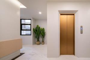 a hallway with a wooden door and a plant at Samyan Serene Hotel in Bangkok