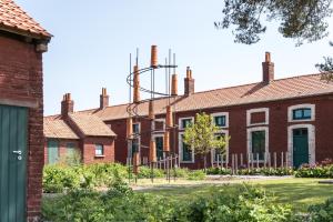 Une rangée de maisons en briques avec cheminées dans l'établissement Cité des Électriciens, à Bruay-la-Buissière