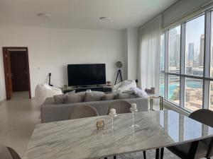 a living room with a couch and a table with wine glasses at Splendid Apartments with Burj Khalifa and Fountain View in Dubai