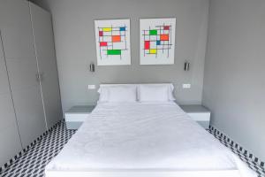 sypialnia z białym łóżkiem i 2 witrażami w obiekcie La Casa de Carlota w mieście Montánchez