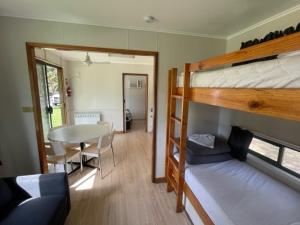a room with bunk beds and a table and a dining room at Penola Coonawarra Caravan Park in Penola