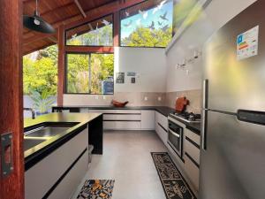a kitchen with a sink and a refrigerator at Chalé Litoral Norte - em condomínio de praia in Camaçari