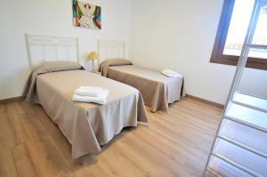 Habitación con suelo de madera y 2 camas. en Casa Los Manolos en Vilanova de Arousa, en Villanueva de Arosa