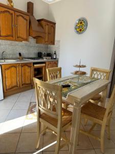 a kitchen with a wooden table and chairs and a kitchen with a sink at La casa del mulino in Catania