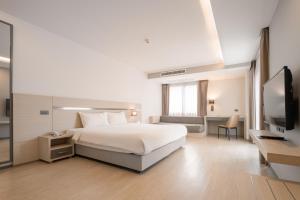 a hotel room with a bed and a television at Samyan Serene Hotel in Bangkok