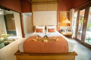 a bedroom with a large bed in a room with windows at Seminyak Sanctuary Villa by Ini Vie Hospitality in Legian