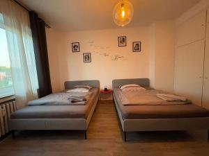 dwa łóżka w pokoju ze ścianą z rysunkami na ścianie w obiekcie Ruhrpott Apartment Zentral Comfort w mieście Herne