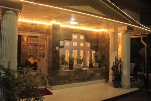 a front porch with potted plants and lights at Namdul Boutique in Gangtok