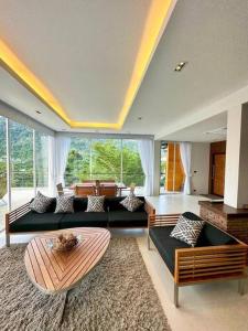 una gran sala de estar con sofás y una mesa. en Luxury 2Bedroom Retreat Penthouse Kamala, en Phuket