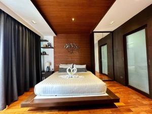 Un dormitorio con una cama grande con una flor. en Luxury 2Bedroom Retreat Penthouse Kamala, en Phuket