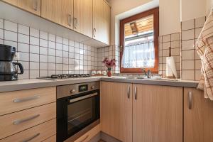 una cucina con mobili in legno, un lavello e una stufa di Vineyard Cottage Pyramid - Happy Rentals a Dobrnič