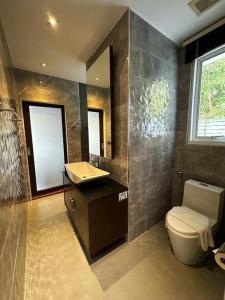 baño con aseo y lavabo y ventana en Luxury 2Bedroom Retreat Penthouse Kamala, en Phuket
