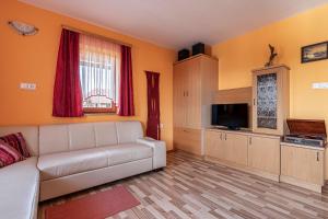 ein Wohnzimmer mit einem Sofa und einem TV in der Unterkunft Vineyard Cottage Pyramid - Happy Rentals in Dobrnič