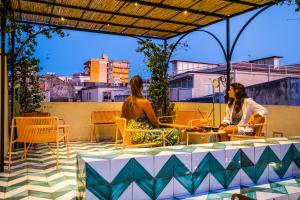 a group of three women sitting at a table on a patio at Regina Bianca - Camere, Suite & Spa - Sciacca in Sciacca