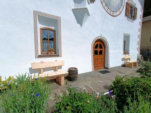 a building with a wooden door and a bench at Gosthof Kastelruth in Castelrotto