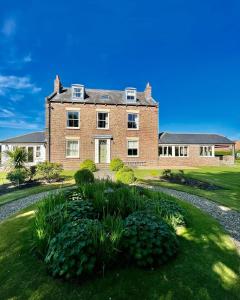 una gran casa de ladrillo con un jardín delante de ella en Wressle Grange (farmhouse), en Selby