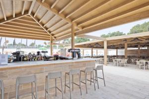 eine Bar mit Stühlen und Tischen in einem Pavillon in der Unterkunft Hotel Best Delta in Maioris Decima