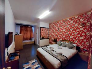 a bedroom with a large bed with a red wall at Namdul Boutique in Gangtok