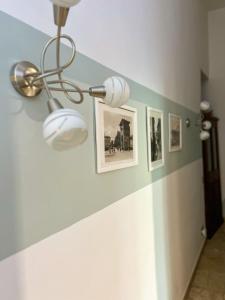 a hallway with a ceiling light and pictures on a wall at Leopoldini Appartamenti in Florence