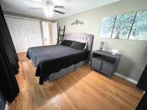 a bedroom with a bed and a wooden floor at Gorgeous Home w Pool & Hot Tub in Schenectady