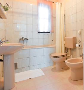 W łazience znajduje się toaleta, wanna i umywalka. w obiekcie Apartments Doda w mieście Zadar +29 zdjęć