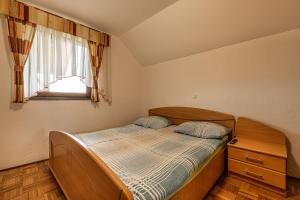 a small bedroom with a bed and a window at Vineyard Cottage Ucman - Happy Rentals in Otočec