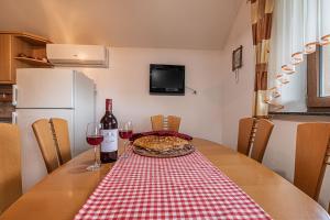uma mesa com uma pizza e dois copos de vinho em Vineyard Cottage Ucman - Happy Rentals em Otocec