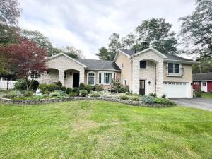 ein Haus mit einem Rasenplatz davor in der Unterkunft Gorgeous Home w Pool & Hot Tub in Schenectady