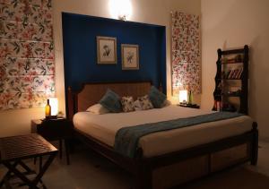 una camera con un grande letto con una parete blu di Chanoud House a Jodhpur