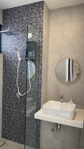a bathroom with a sink and a shower with a mirror at MMJ Homesuite @ The Shore in Kota Kinabalu