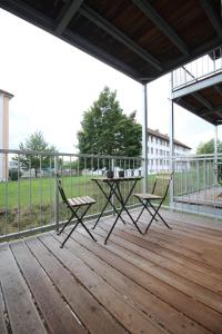 a patio with a table and chairs on a deck at MOWO Marshall 8 - Apartmenthaus Kitzingen - großzügige Wohnungen für je 6 Personen mit Balkon in Kitzingen